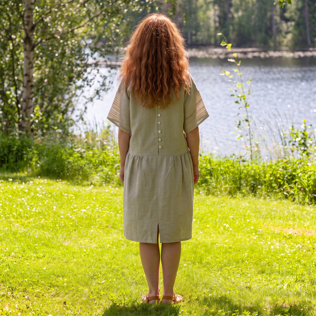 Närbild på ljusgrå linnepasspoaler, sju kokosknappar med handgjorda öglor och fickor vid höfterna i en handgjord klänning.